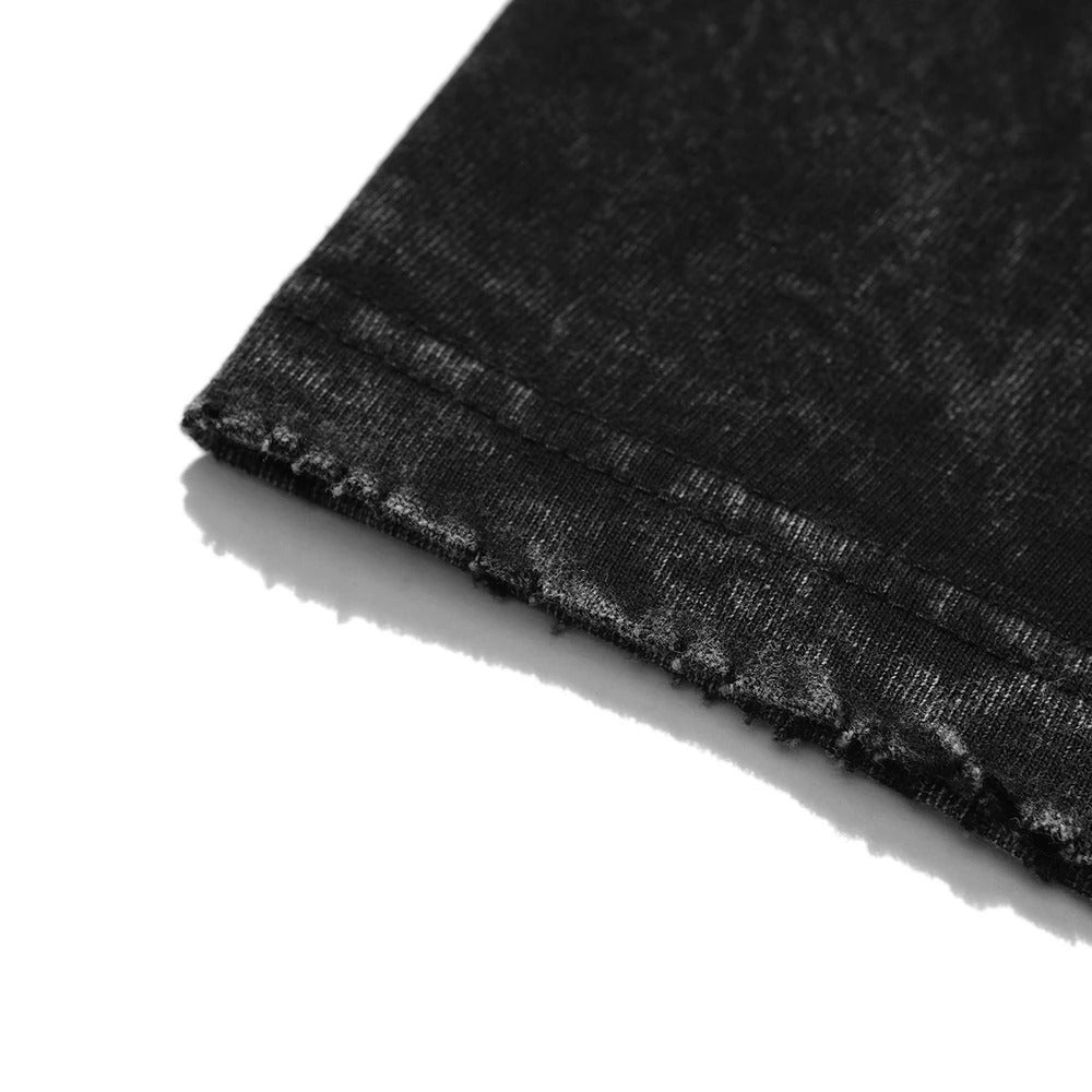 Macro close-up of the distressed and frayed sleeve hem detailing on a 240 GSM vintage black acid wash oversized t-shirt