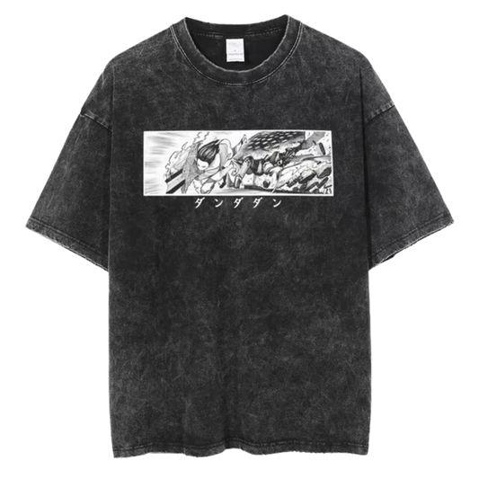 A black t-shirt with a distressed print of a manga panel from the series "Dandadan." The panel features Ken Takakura in action, with the Japanese text "タツヤ" (Tatsuya) written below.