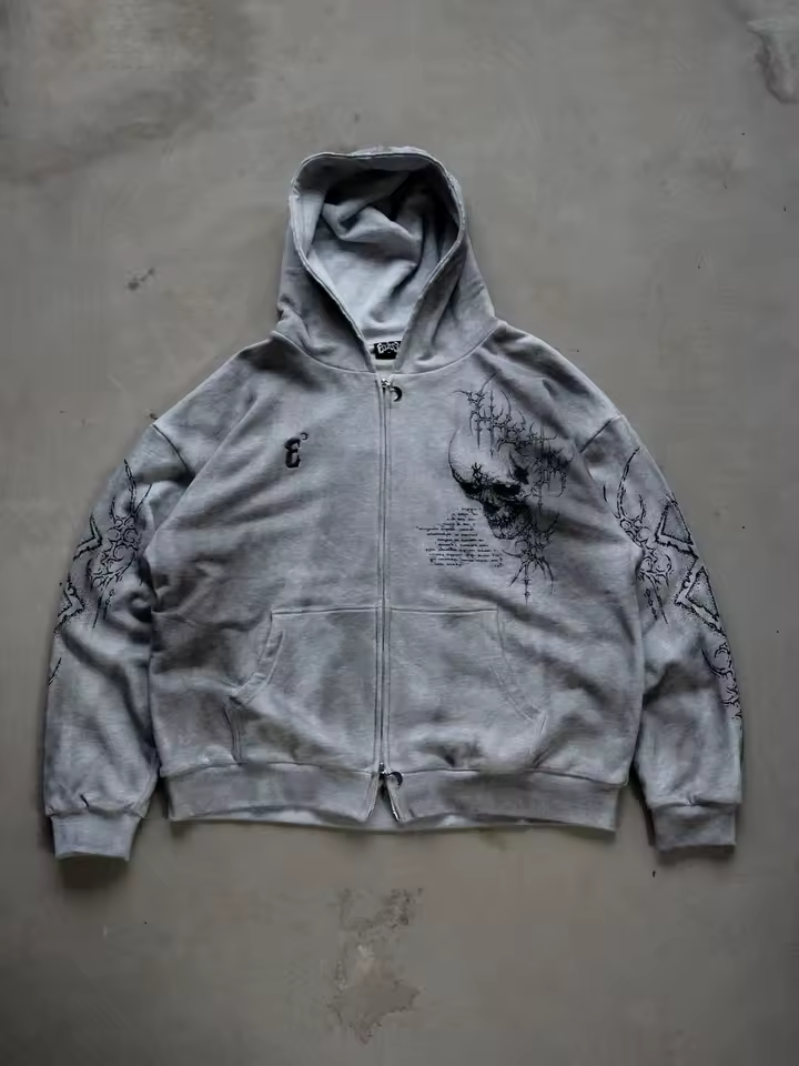 Front view of a heather grey heavyweight cotton zip-up hoodie featuring a gothic skull graphic and Berserk sleeve prints by SkaiiyPrints.