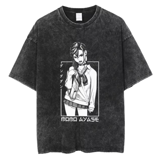 A black t-shirt with a distressed print of Momo Ayase from the manga series "Dandadan." She is depicted in a seductive pose, with the Japanese text "タツヤ" (Tatsuya) written above her. The text "MOMO AYASE" is written in bold letters below the image.