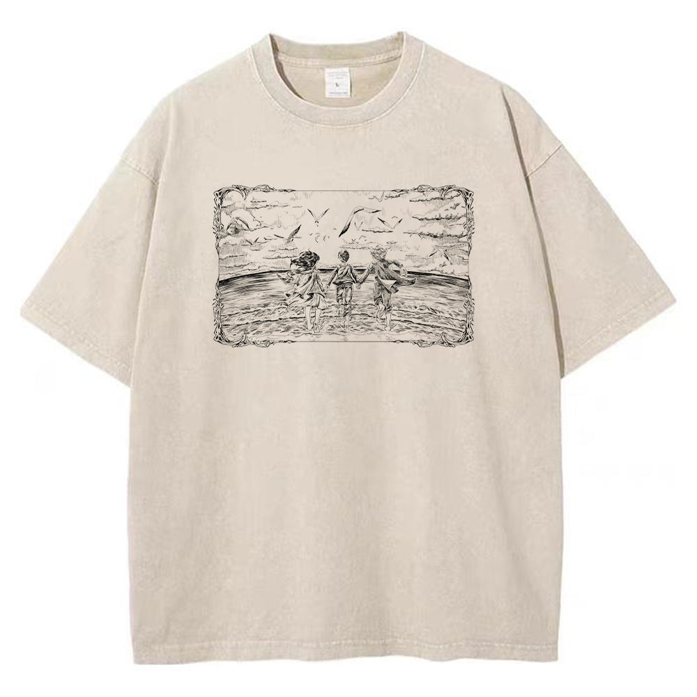 Front view of vintage sand acid wash t-shirt featuring framed graphic of Eren, Mikasa, and Armin at the ocean.
