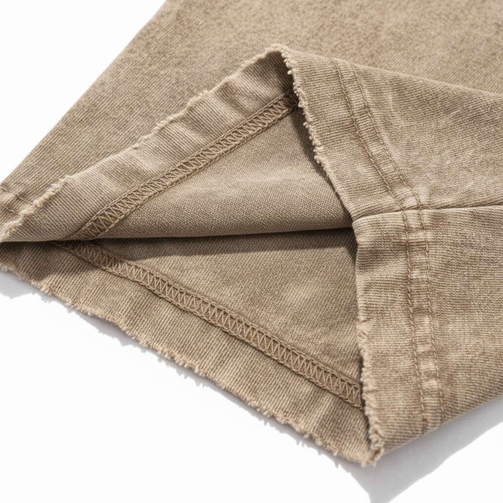 Close up of distressed frayed sleeve hem detailing on a vintage brown heavyweight streetwear t-shirt.