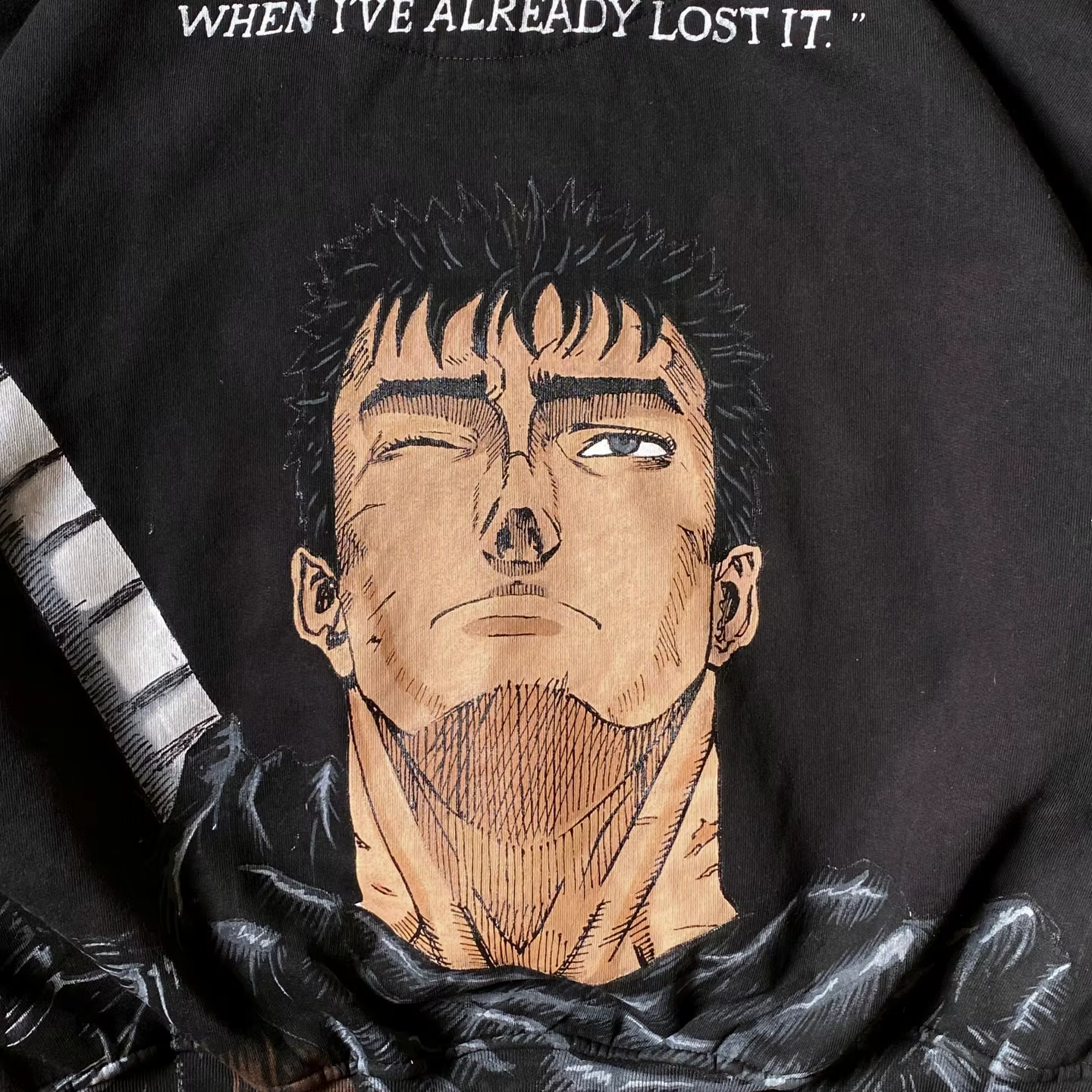 Close-up of the Guts portrait and 'Why do I always realize it' quote printed on a black heavyweight hoodie.