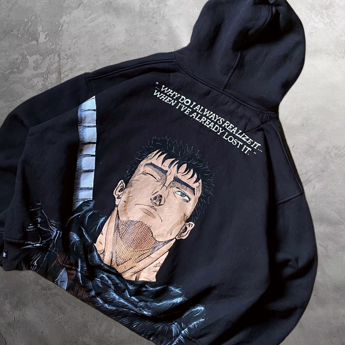 Angled view of the oversized black Berserk hoodie highlighting the back Guts manga graphic and drop-shoulder fit