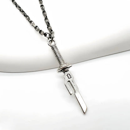 This necklace features a pendant shaped like a dagger. Here's a description of the necklace:

