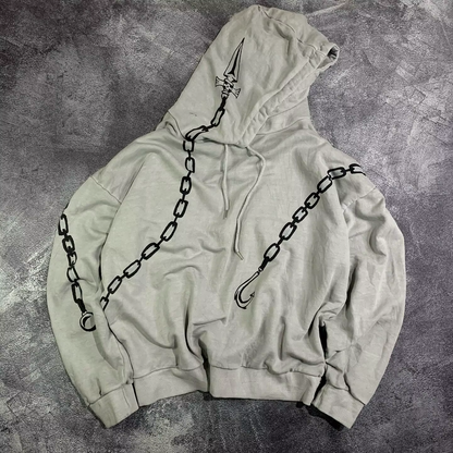 Front view of an oversized grey anime hoodie featuring wrap-around chain graphics and a judgment blade printed on the hood.