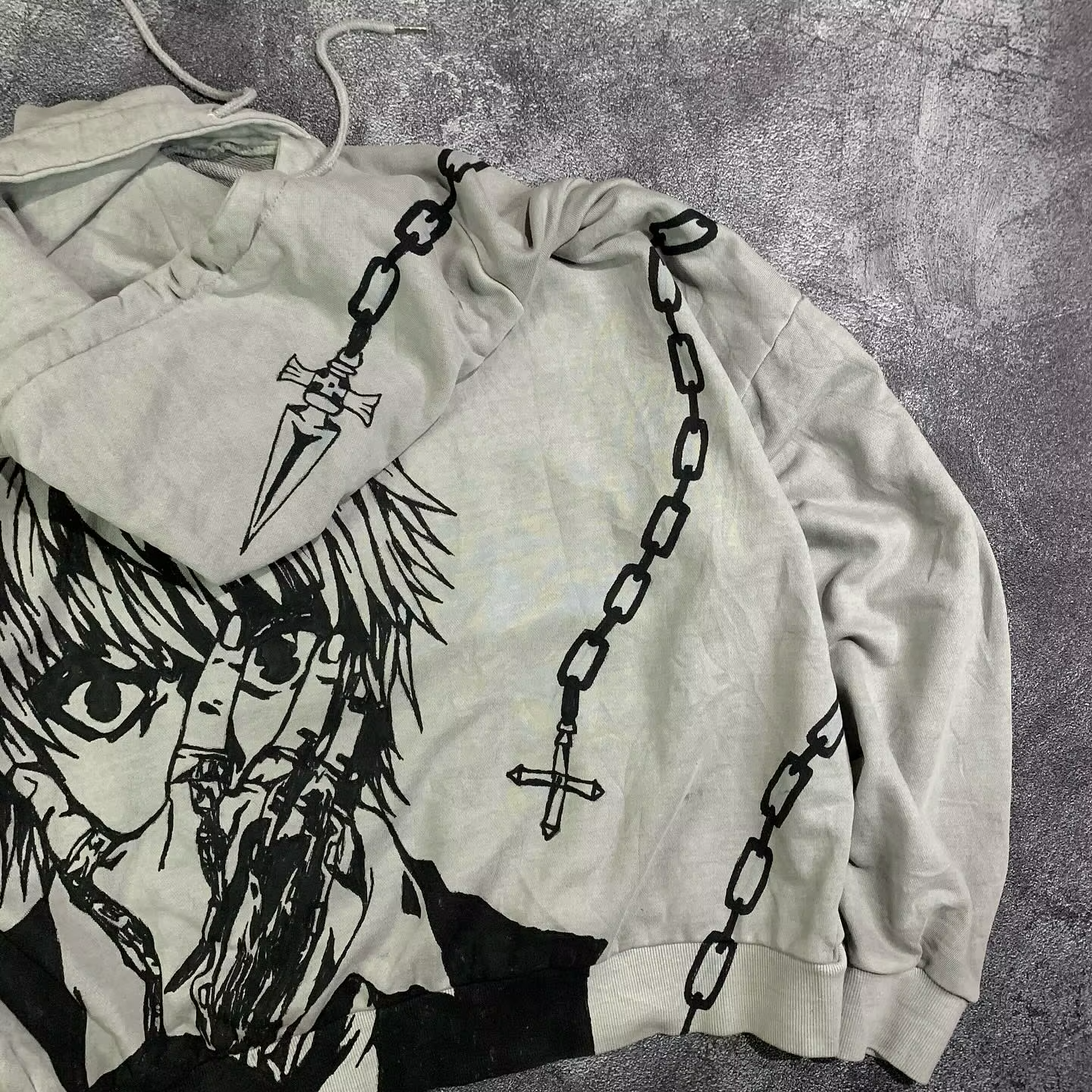 Close-up of the Kurapika judgment blade and chain graphic printed directly onto the hood of a SkaiiyPrints pullover.