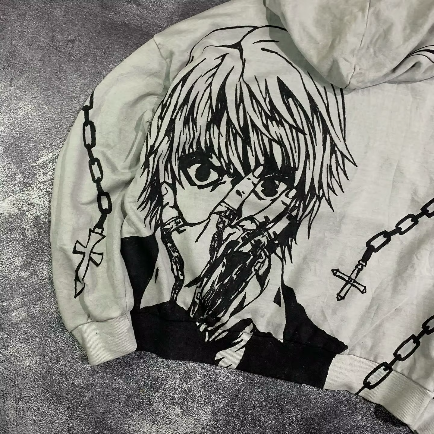 Close-up of the Kurapika manga portrait and cross chain graphics on the back of a premium heavyweight hoodie.