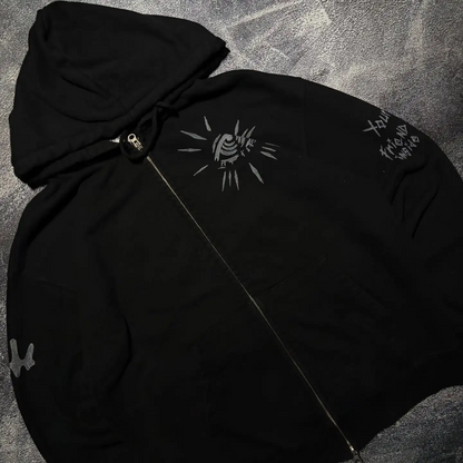 Close-up of custom evil eye and sleeve text embroidery on a black heavyweight zip-up hoodie.
