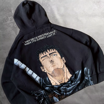 Angled view of the oversized black Berserk hoodie highlighting the back Guts manga graphic and drop-shoulder fit.