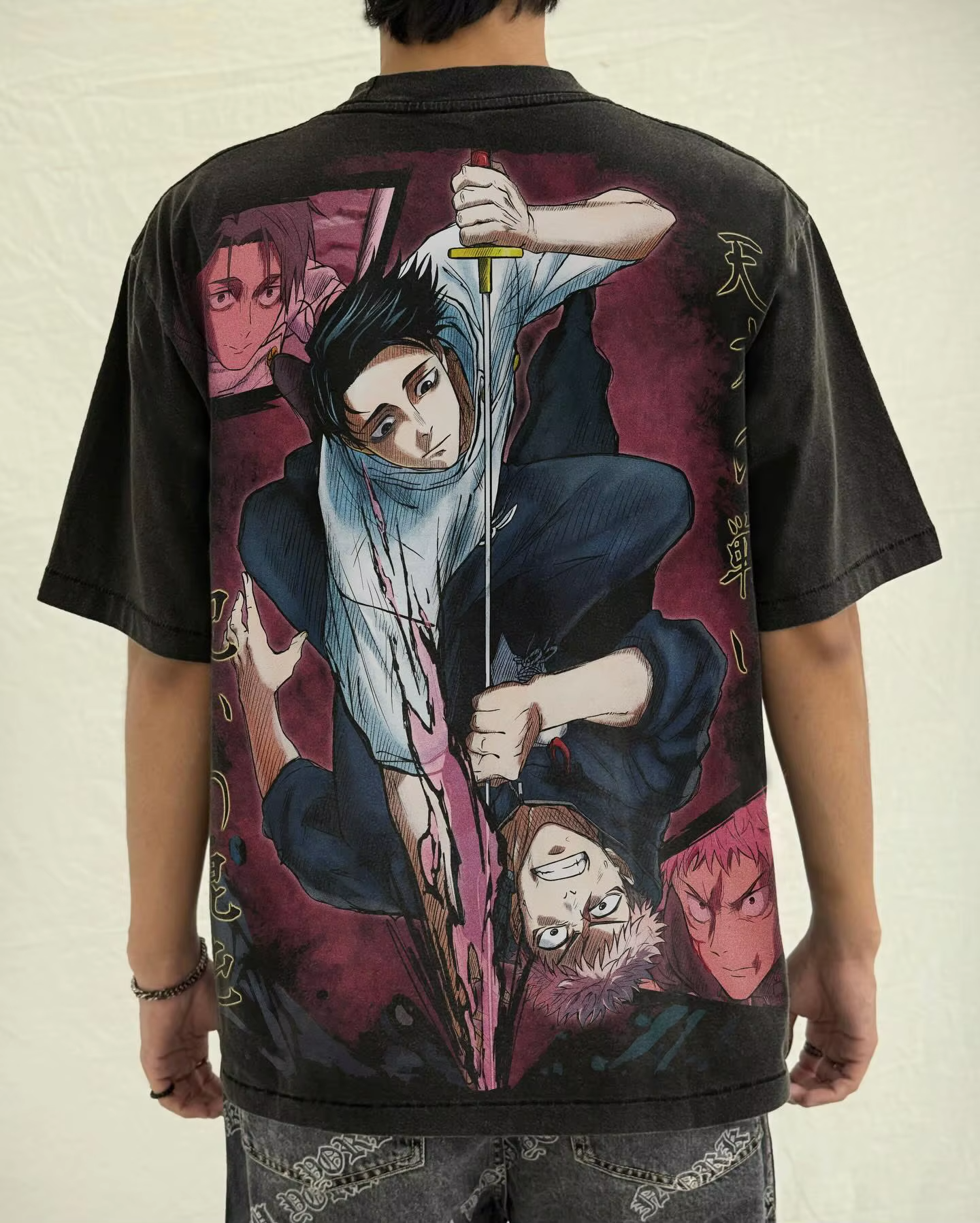Model wearing a vintage washed black Yuta Okkotsu Jujutsu Kaisen oversized graphic t-shirt showing the back combat print.